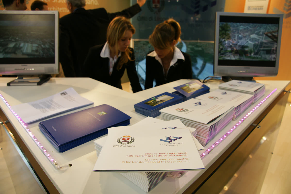 Banco luminoso dello stand con brochure istituzionale e hostess