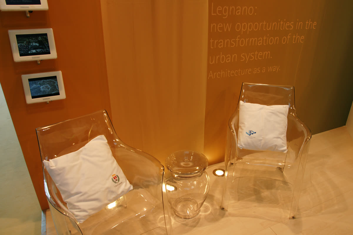 Area lounge dello stand con sedute trasparenti e cuscini brandizzati