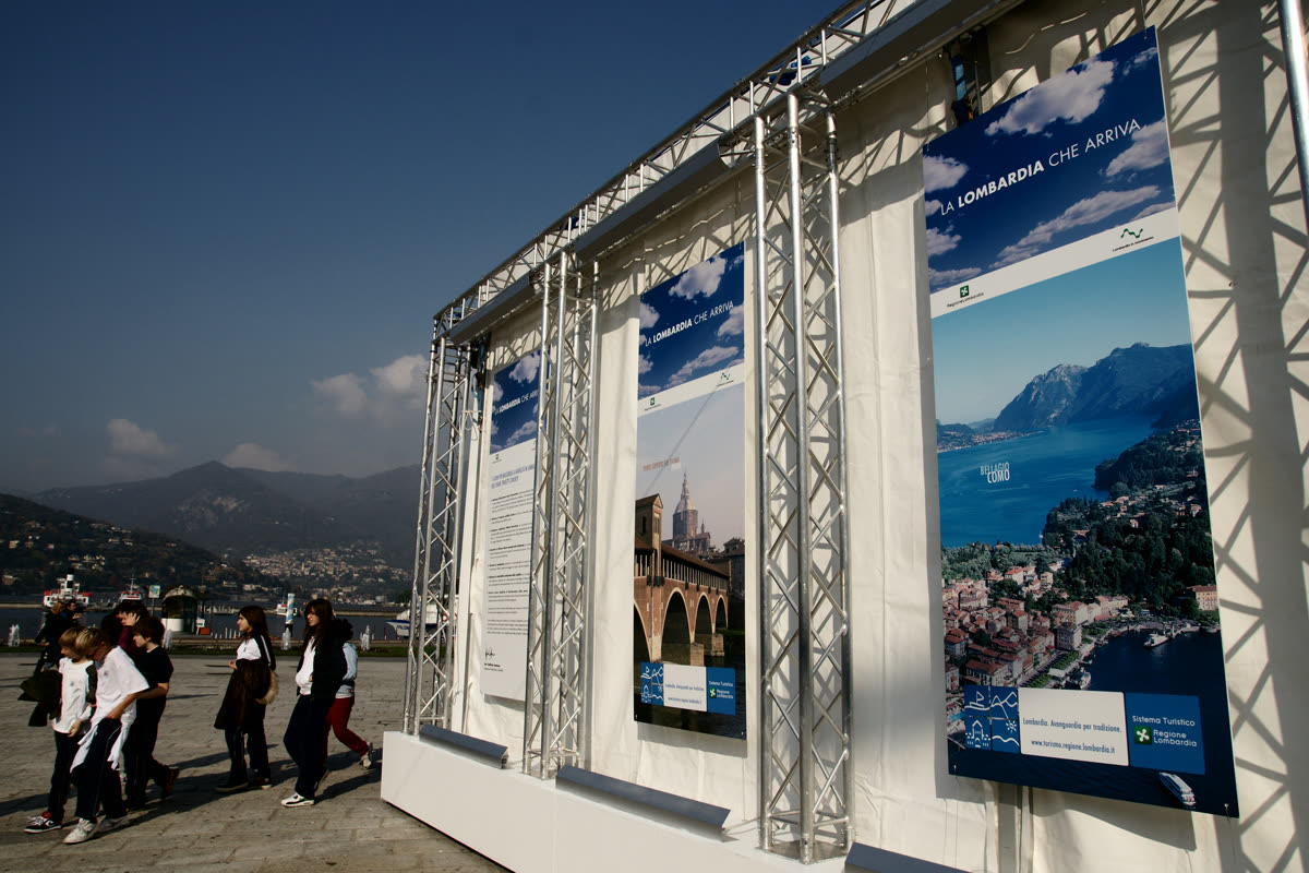 Scolaresca passa davanti ai banner del padiglione sul lungolago di Lecco