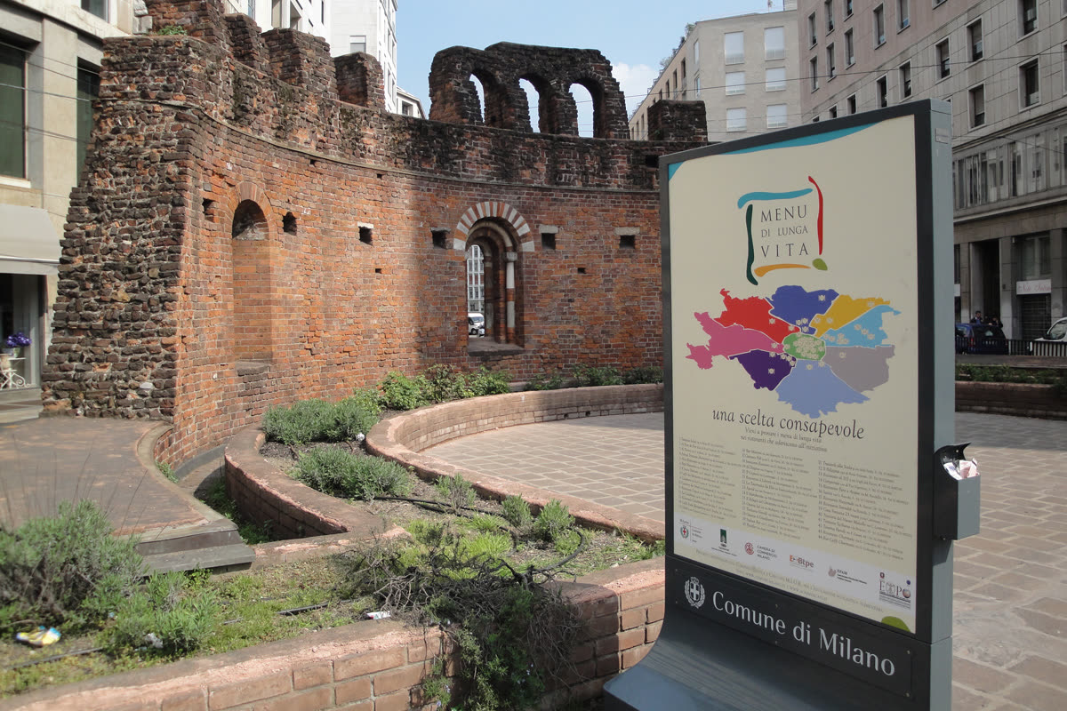 Totem stradale Menu di Lunga Vita davanti alle rovine romane di Milano