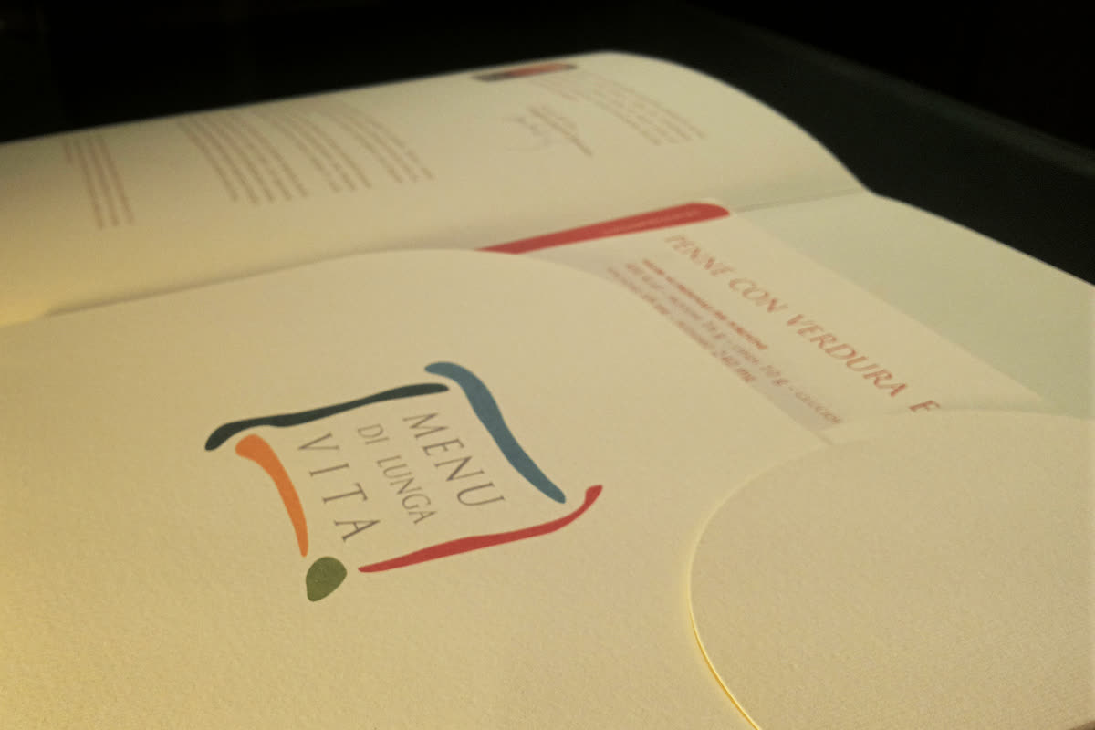 Pieghevole Menu di Lunga Vita aperto con logo e pagina ricetta illuminati