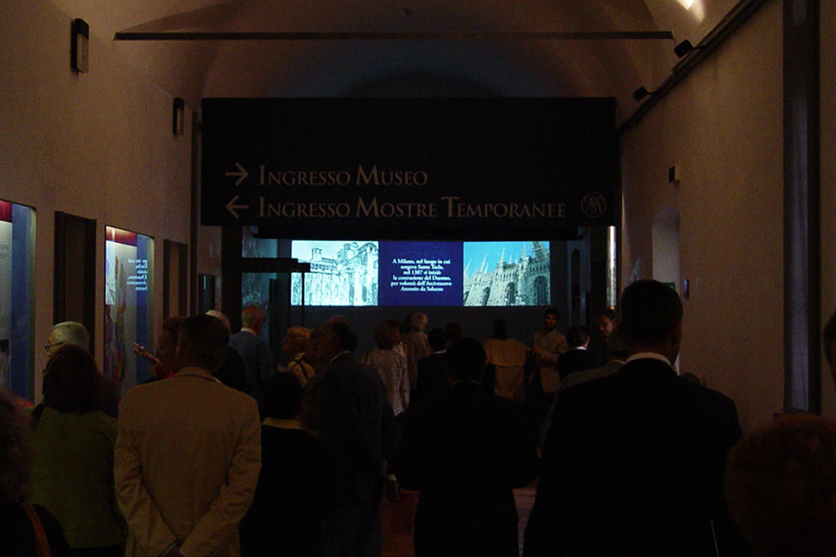 Corridoio del museo con la multivisione proiettata a parete sotto le insegne d'ingresso