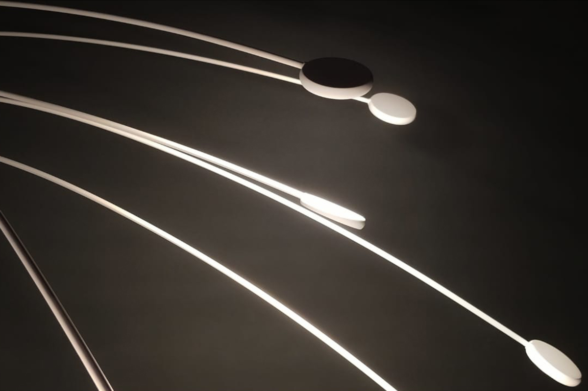 Installazione artistica LUMINA con esili elementi luminosi bianchi nel buio