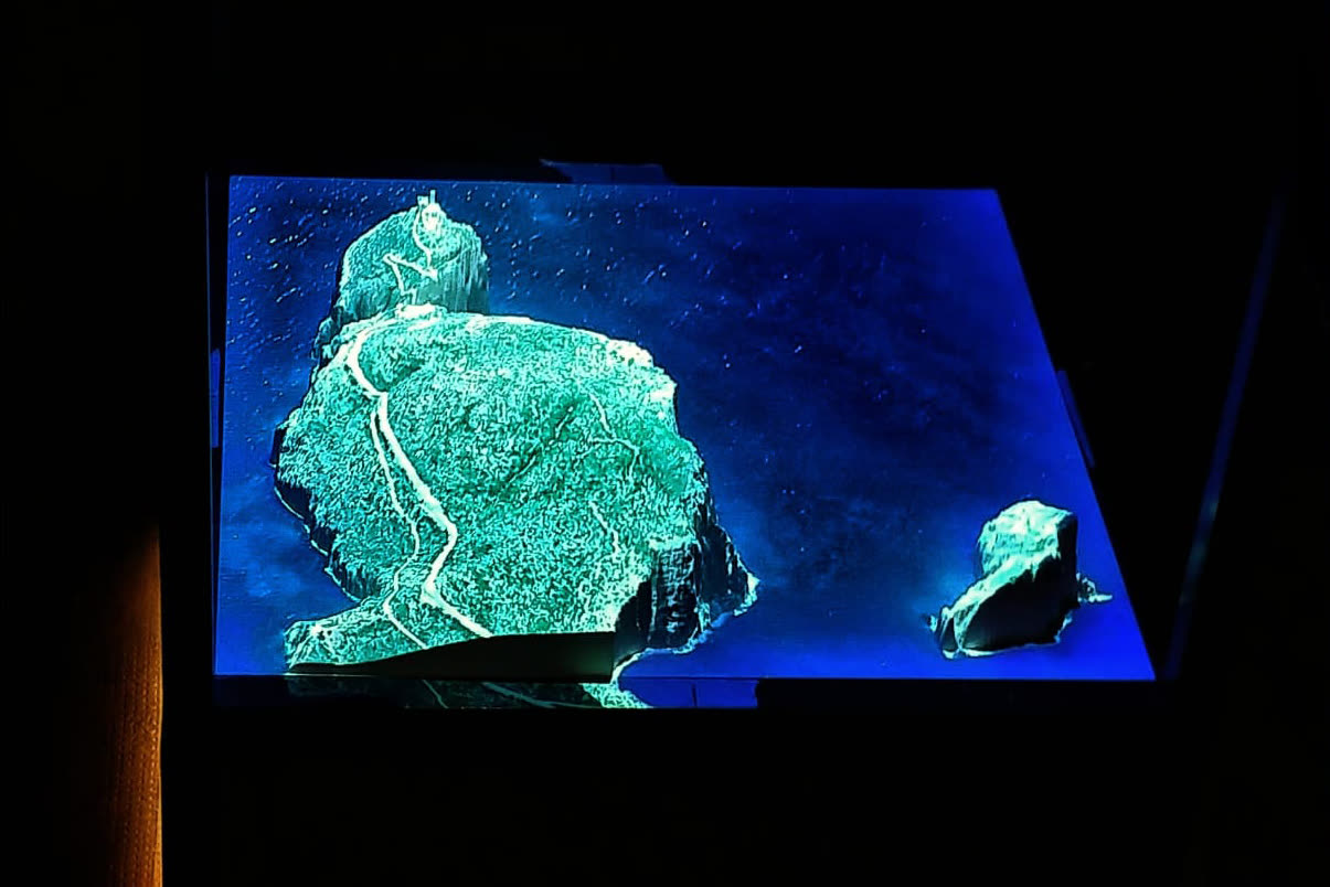 Plastico in rilievo del promontorio con proiezione mappata blu e verde al buio