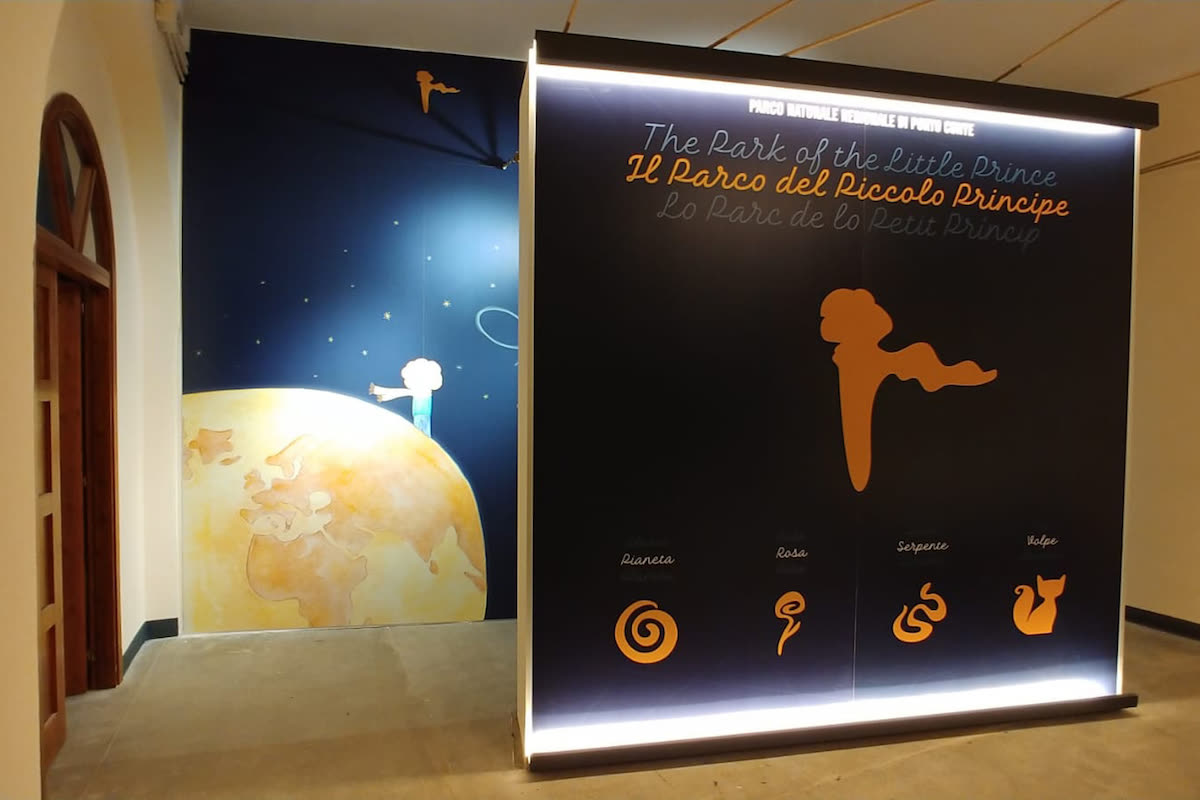 Ingresso con insegna luminosa del Parco del Piccolo Principe e murale del piccolo protagonista