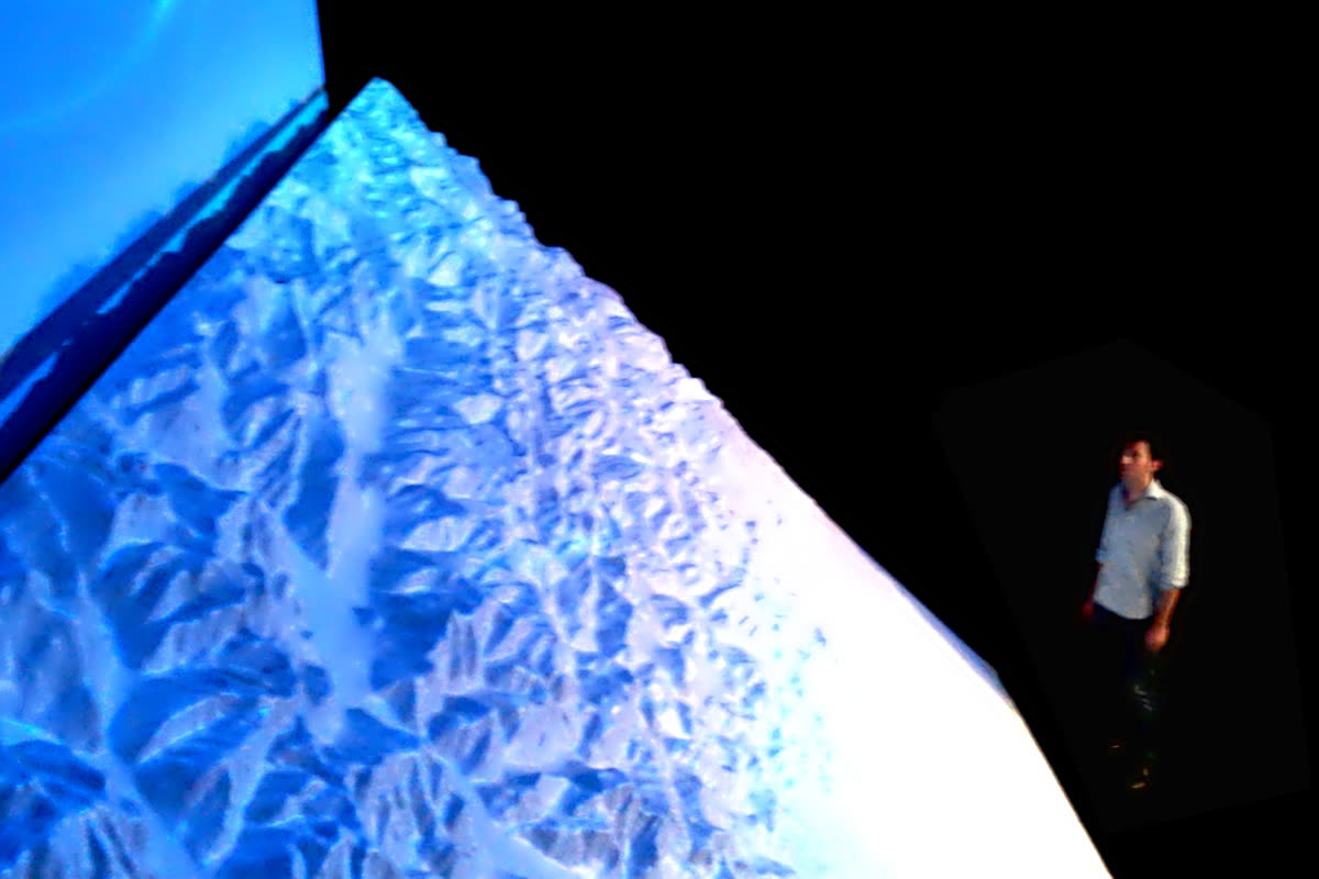 Dettaglio del plastico illuminato in blu dal videomapping, visitatore in silhouette