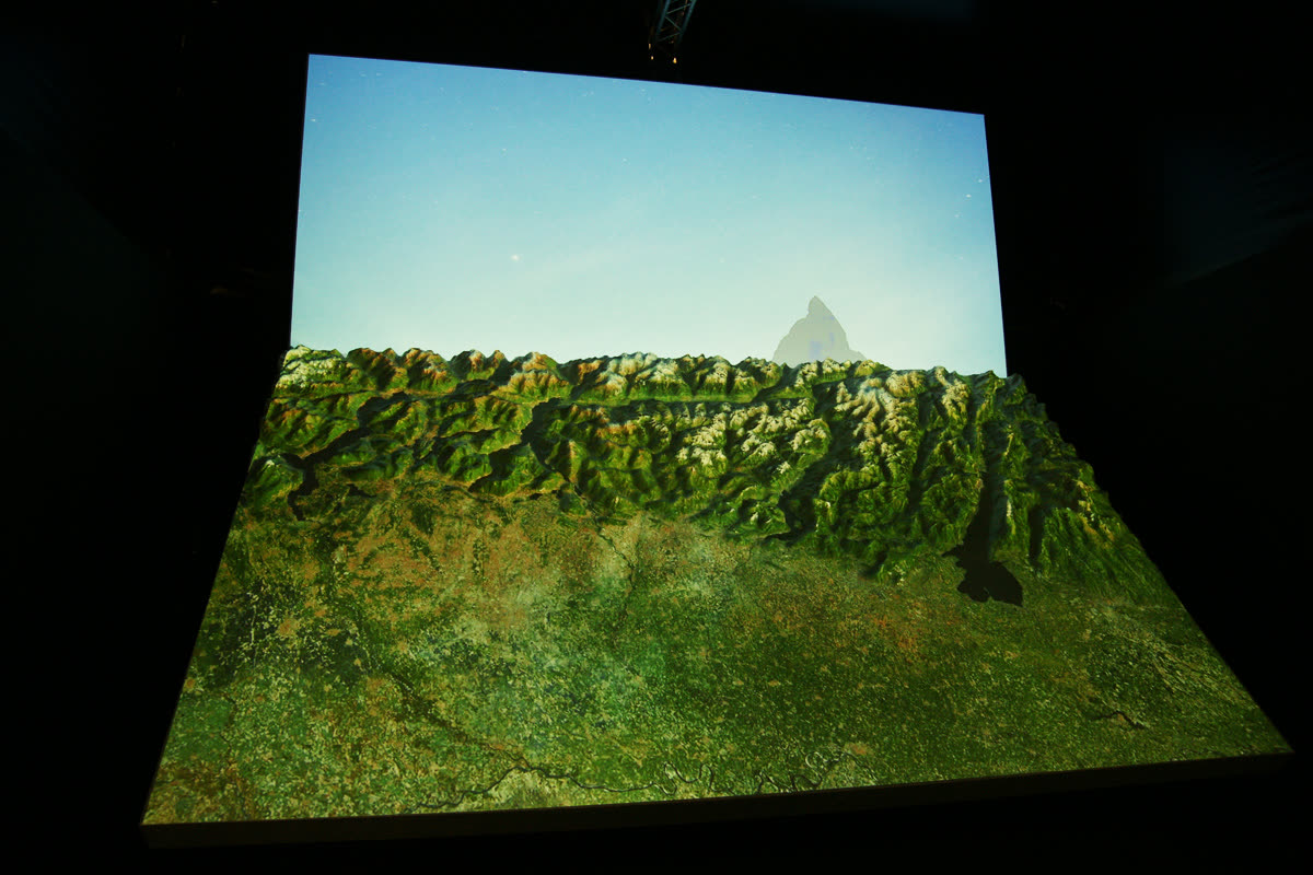 Plastico con videomapping satellitare verde del territorio e cielo digitale sullo schermo