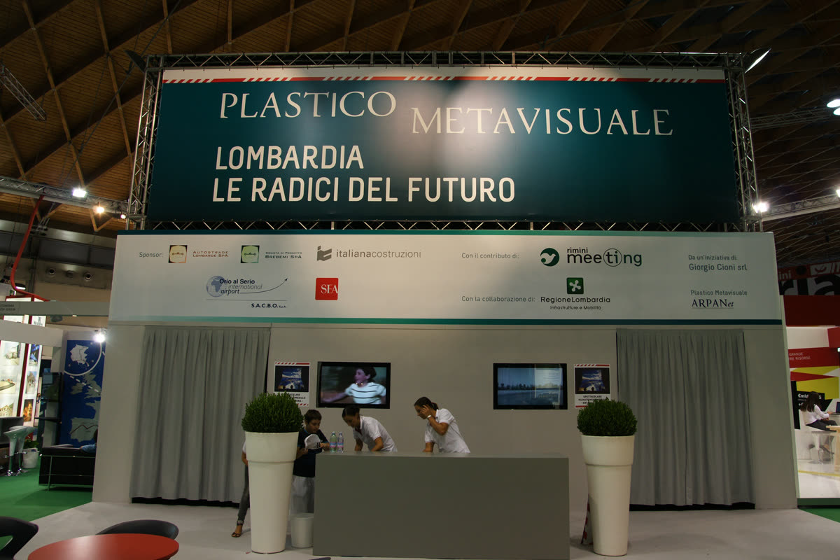 Facciata dello stand con banner del progetto, loghi sponsor e desk accoglienza