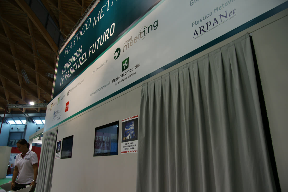 Insegna superiore dello stand con loghi ARPANet e Regione Lombardia, addetta e tende
