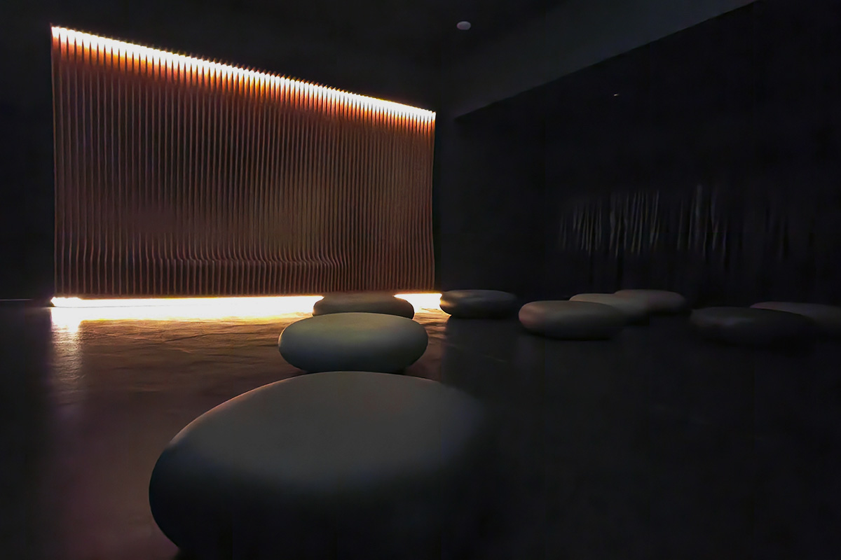 Parete parametrica in legno retroilluminata e sedute Slide Chubby Low by Marcel Wanders nella sala immersiva