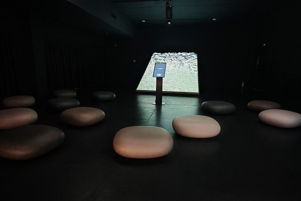 Sala buia con sedute Slide Chubby Low by Marcel Wanders e plancia interattiva davanti al Plastico metavisuale della provincia di Bergamo